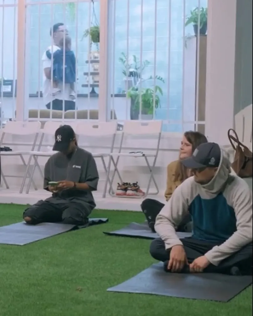 Guests seated on yoga mats on the turf yard during a wellness session